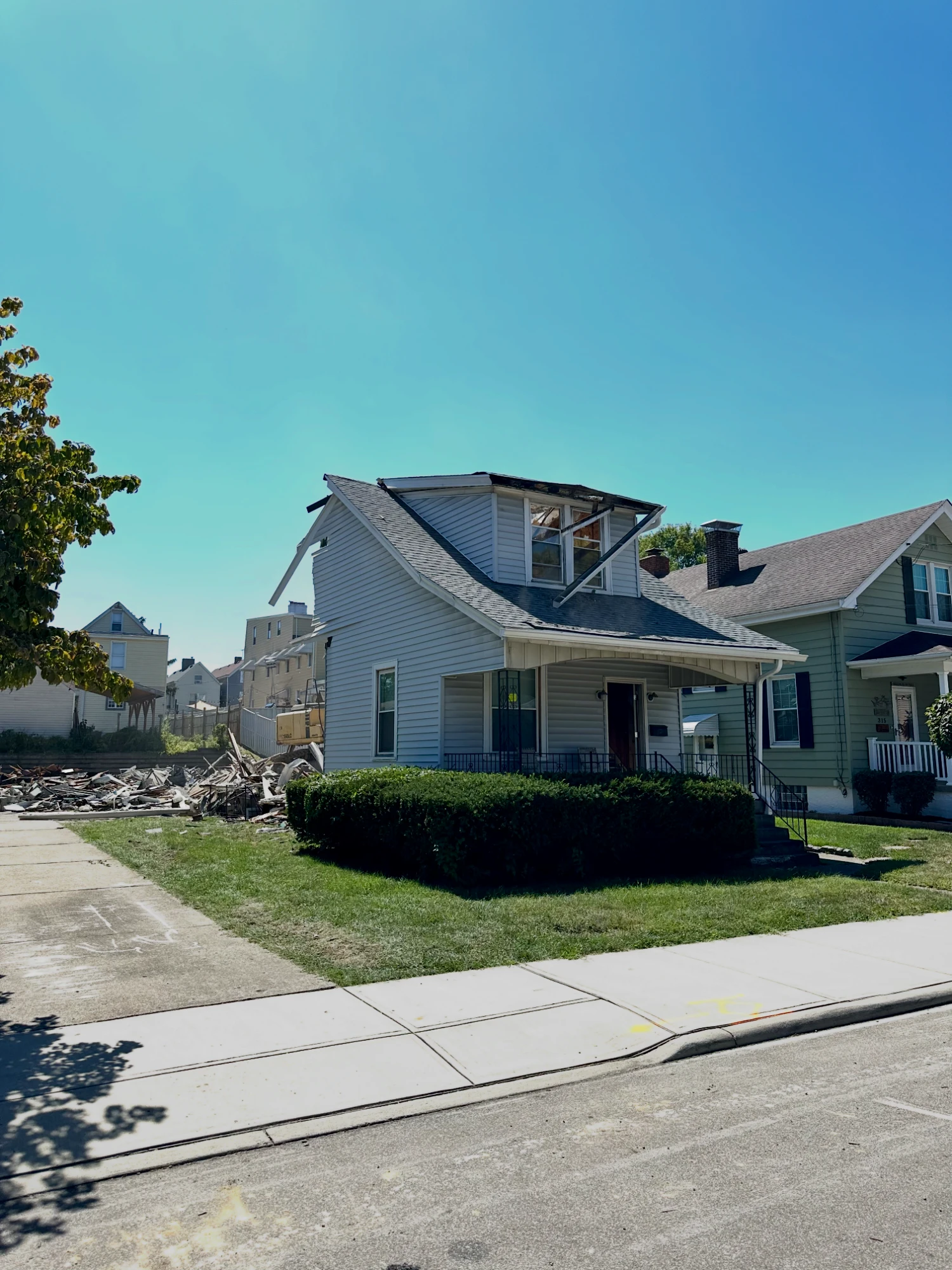 Before: the original house partly torn down, with demolition debris piled beside it