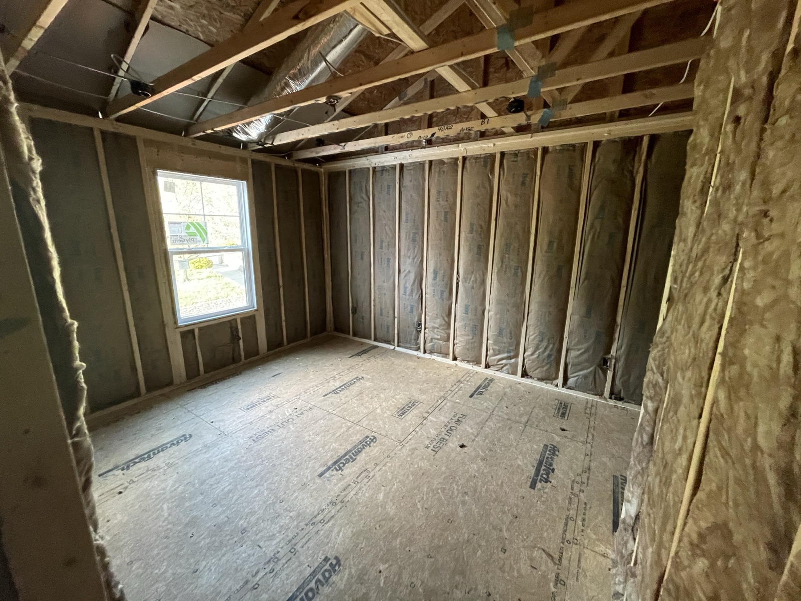 A framed and insulated bedroom with a clean subfloor and no debris