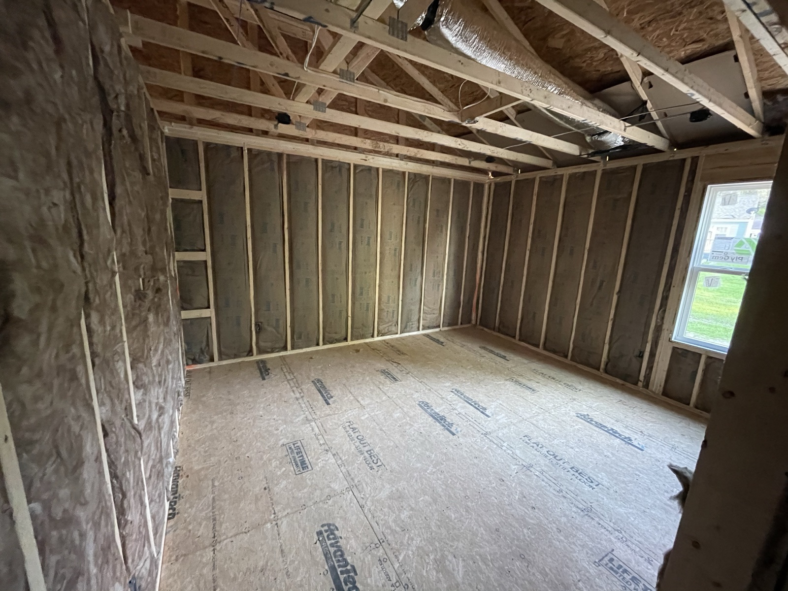 An insulated room in a new home with the subfloor swept clean