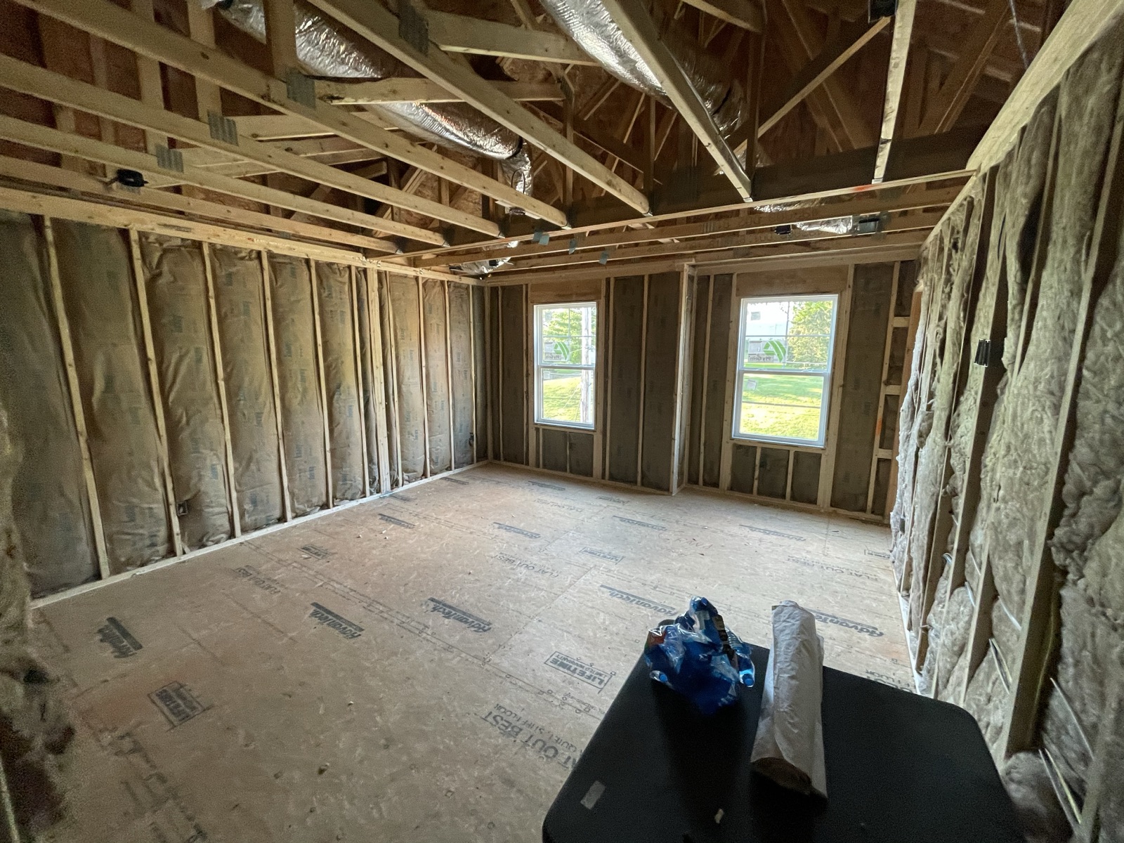 A large upstairs room, framed and insulated, with a tidy swept floor