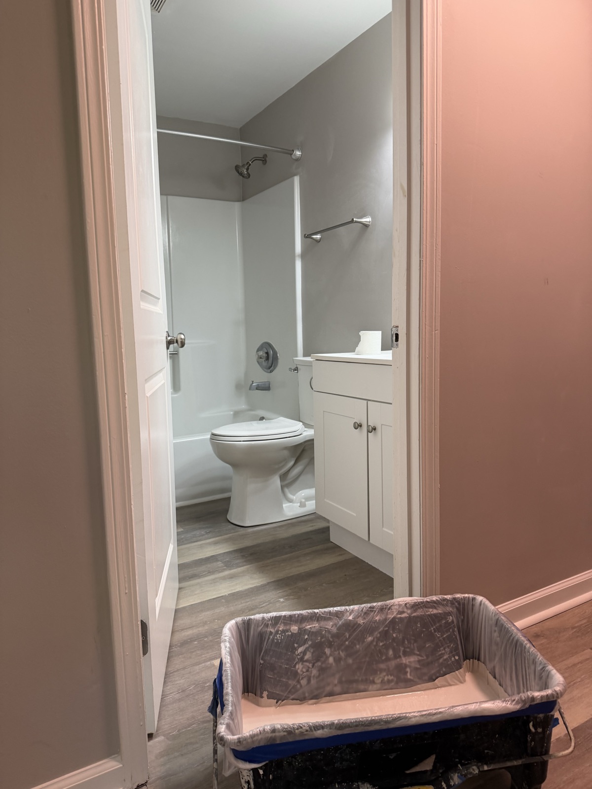 A freshly painted apartment bathroom with a white vanity and tub