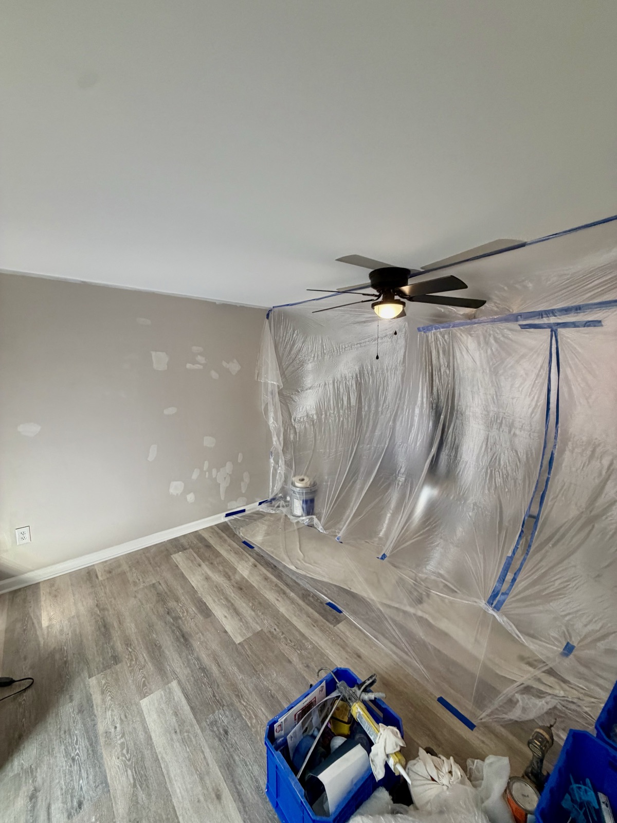 An apartment bedroom covered in plastic sheeting, ready for paint