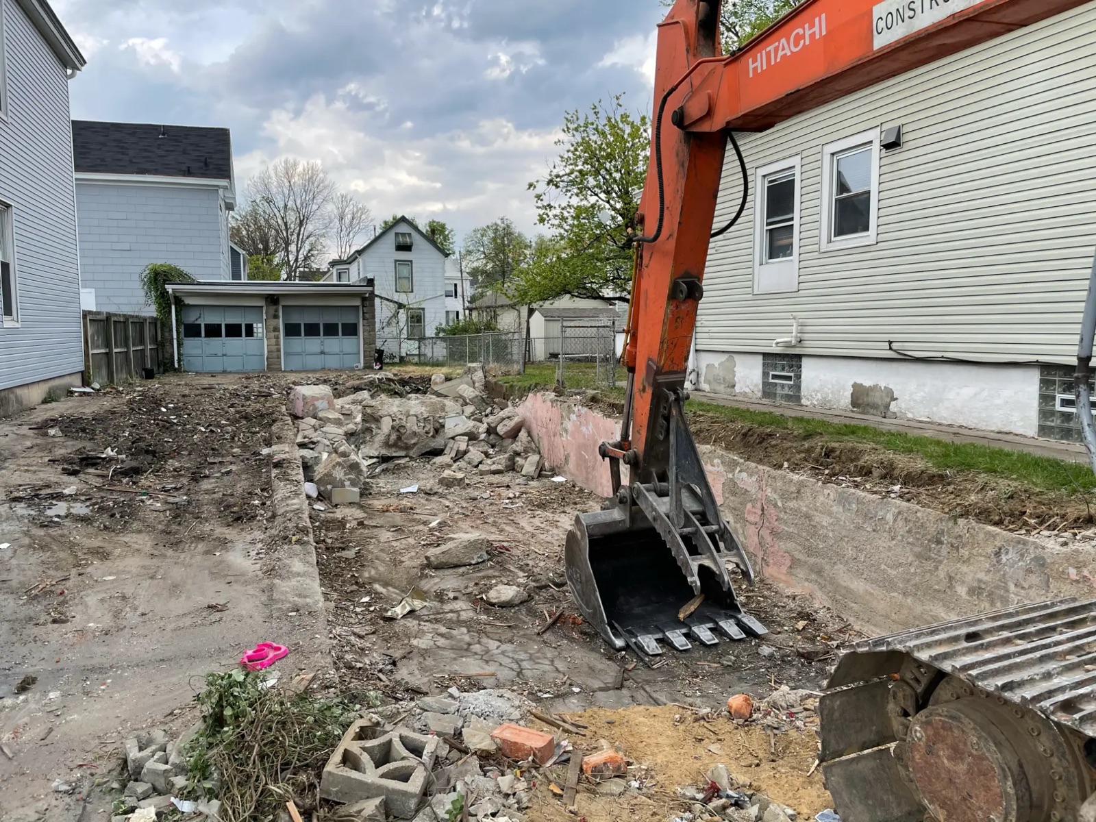 The old basement walls being pulled out with an excavator bucket