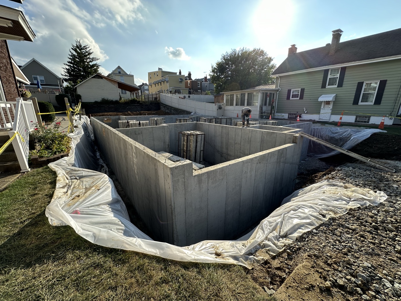 Freshly poured concrete foundation walls in an excavated lot