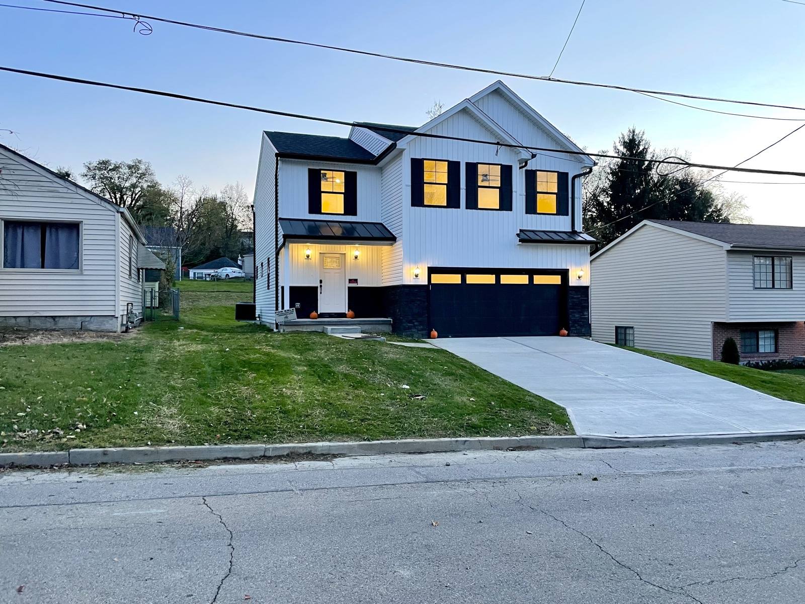 A new two-story home with its windows lit at dusk