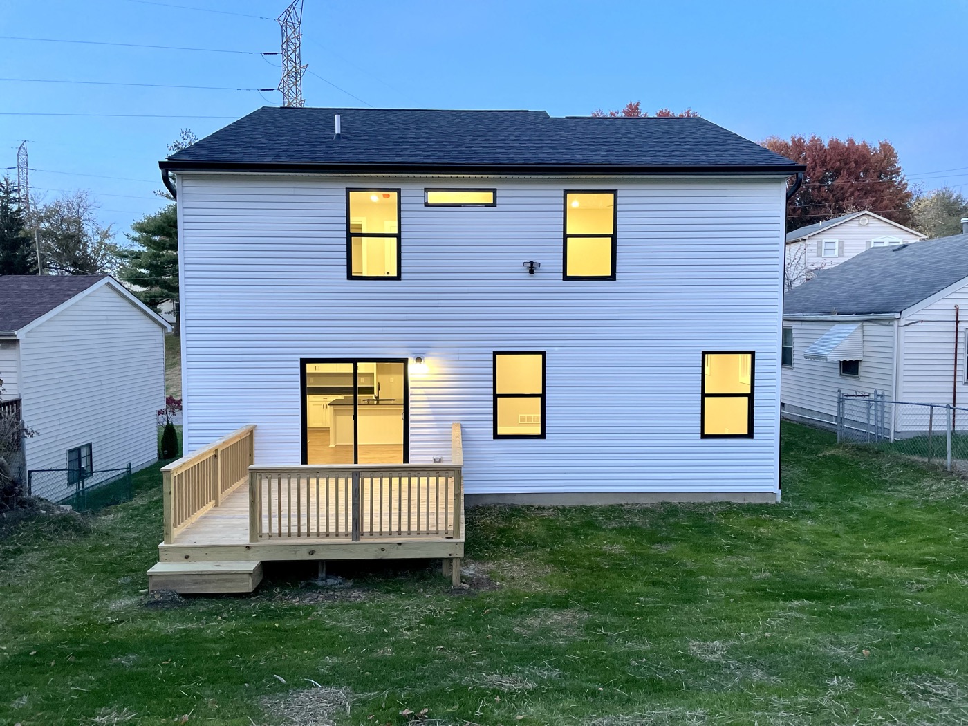 The back of a finished new home with its windows lit
