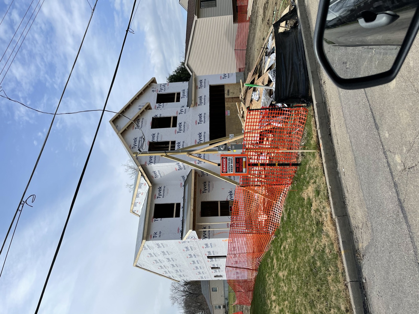 A new house framed, wrapped and fenced off during construction