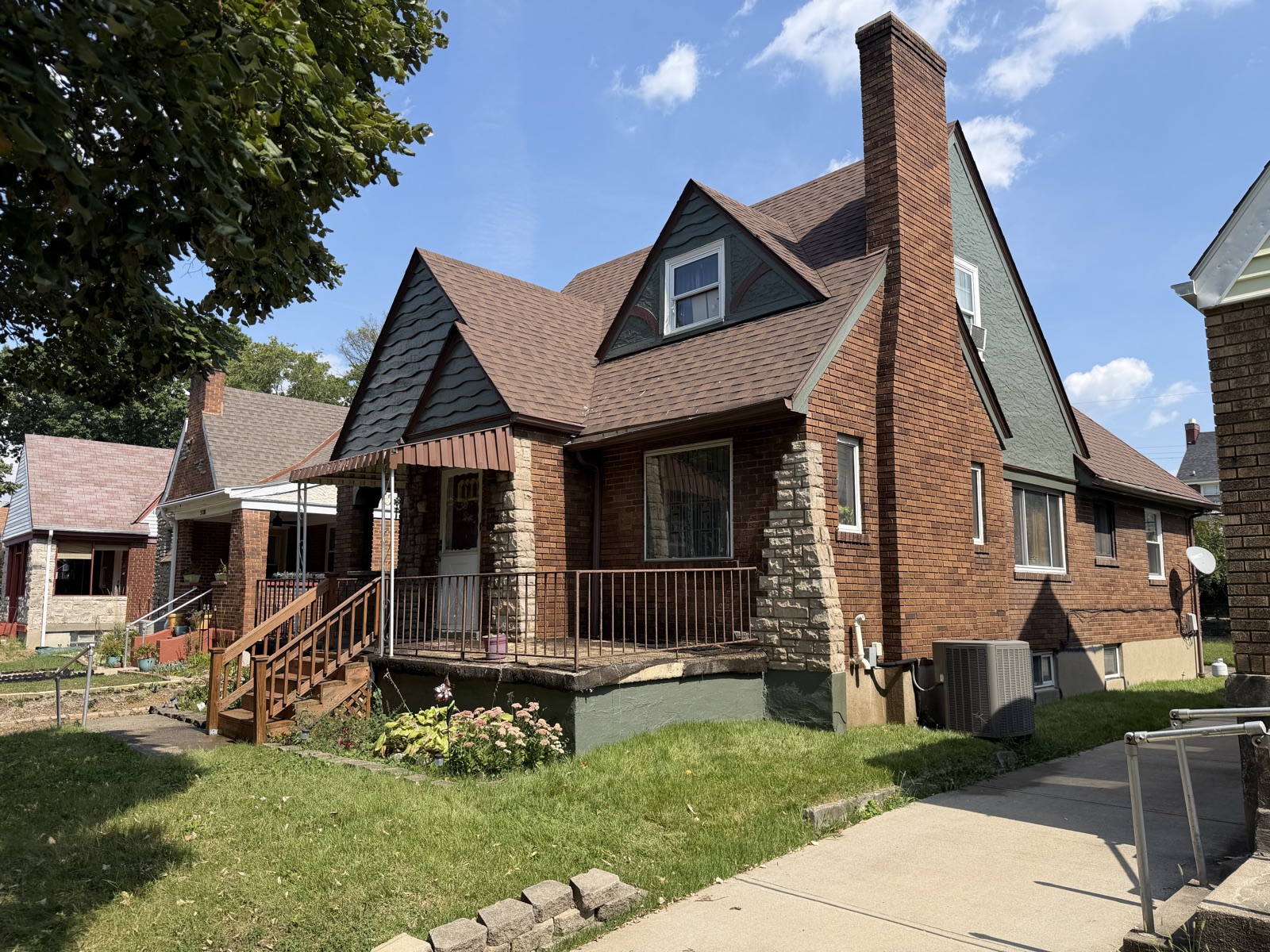 A brick bungalow with its gables and trim repainted dark gray