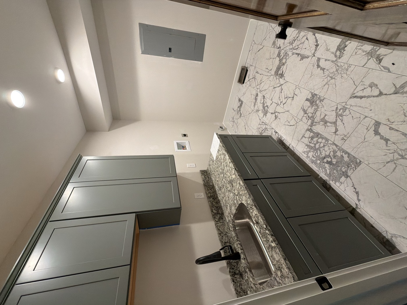 An apartment kitchen with gray cabinets and fresh paint