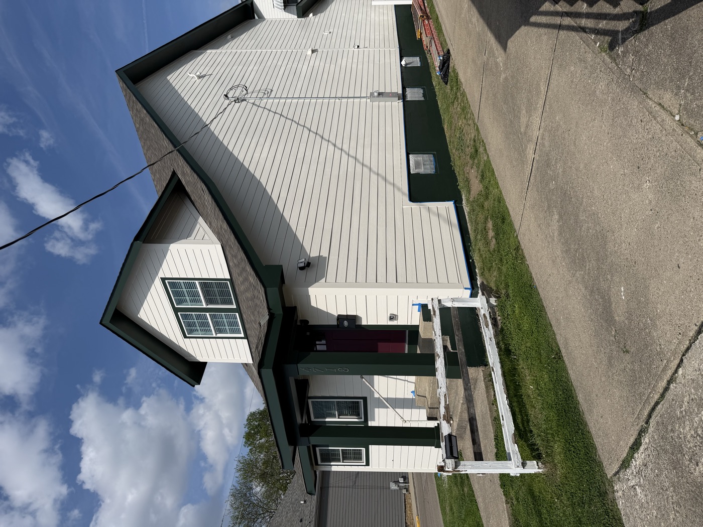 A white house with black trim on a corner lot