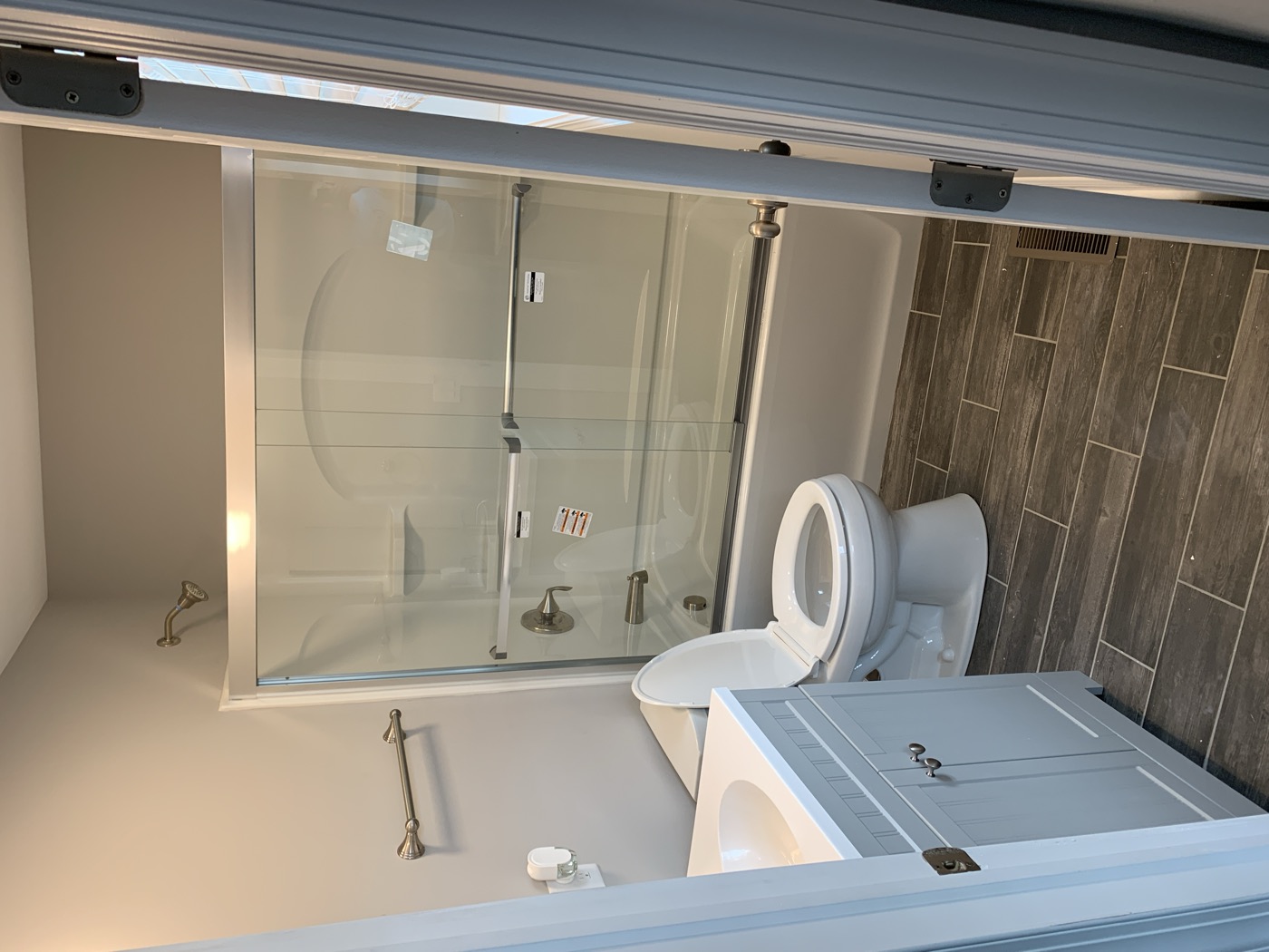 A remodeled bathroom with a tub, glass doors and new vanity