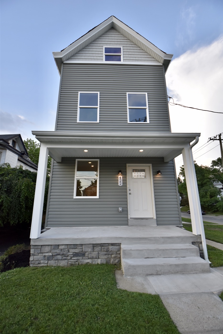 A remodeled gray two-story house with a covered front porch
